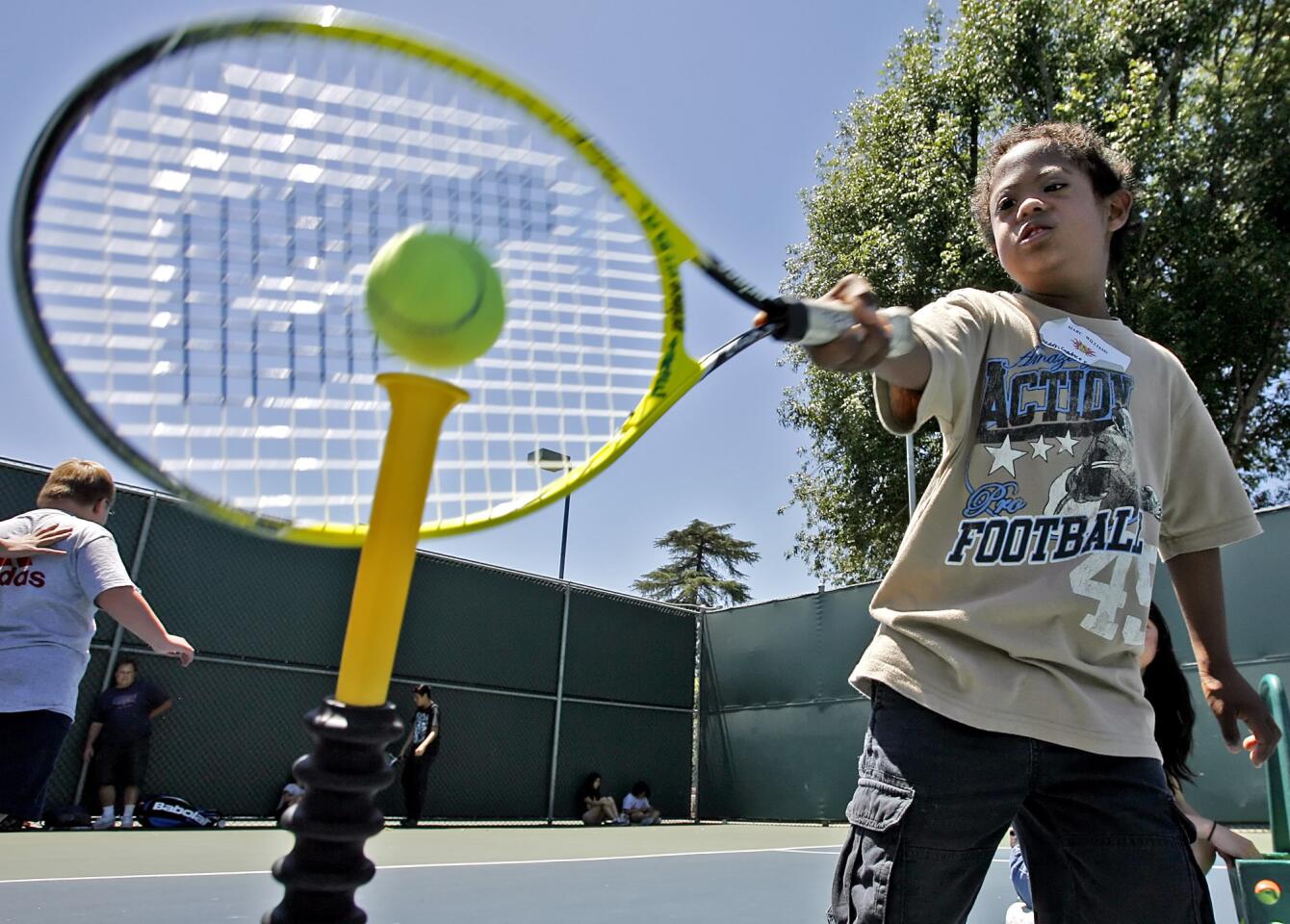 Eight-year old Marc Williams swings at a tennis ball during the annual Jensen-Schmidt Tennis Academy for Special Needs individuals at the Burbank Tennis Center in Burbank on Tuesday, June 26, 2012.