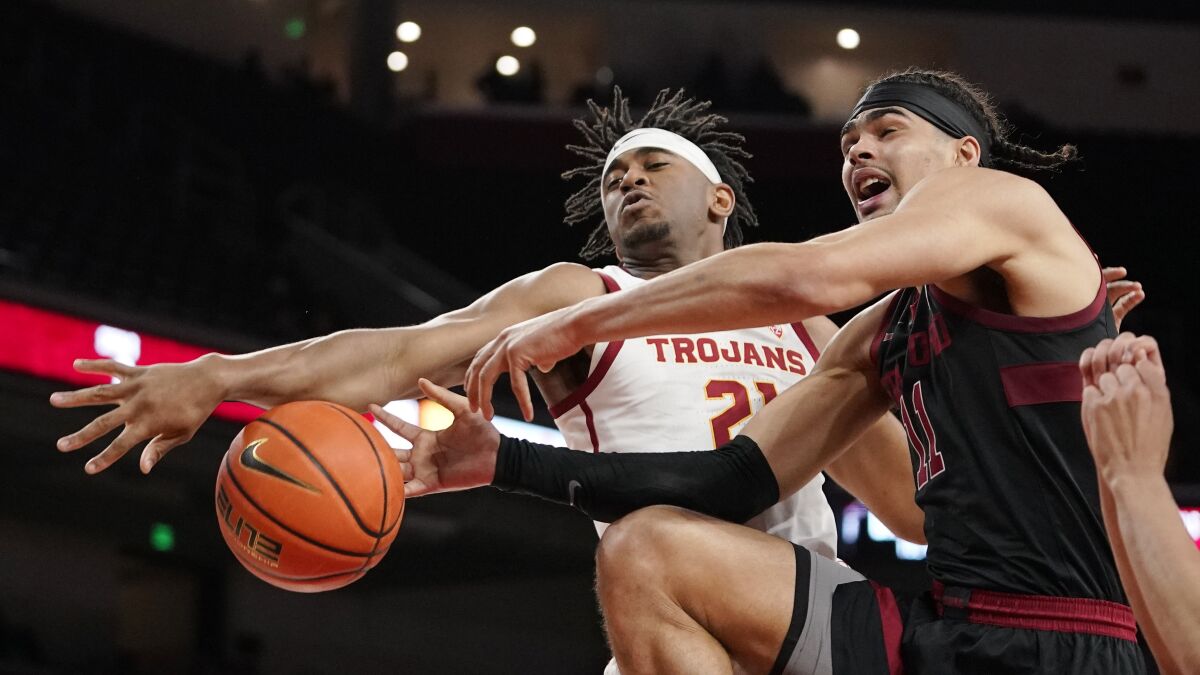 Stanford forward Jaiden Delaire tries to shoot as USC guard Reese Dixon-Waters knocks the ball from his hands.