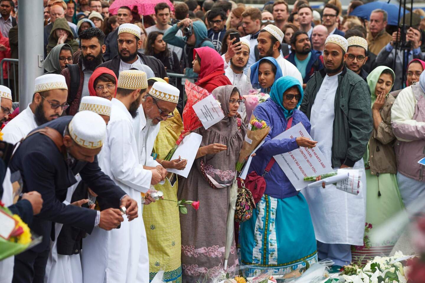 Members of the Dawoodi Bohra Muslim community join others as they lay flowers during a vigil at Potters Fields Park in London.