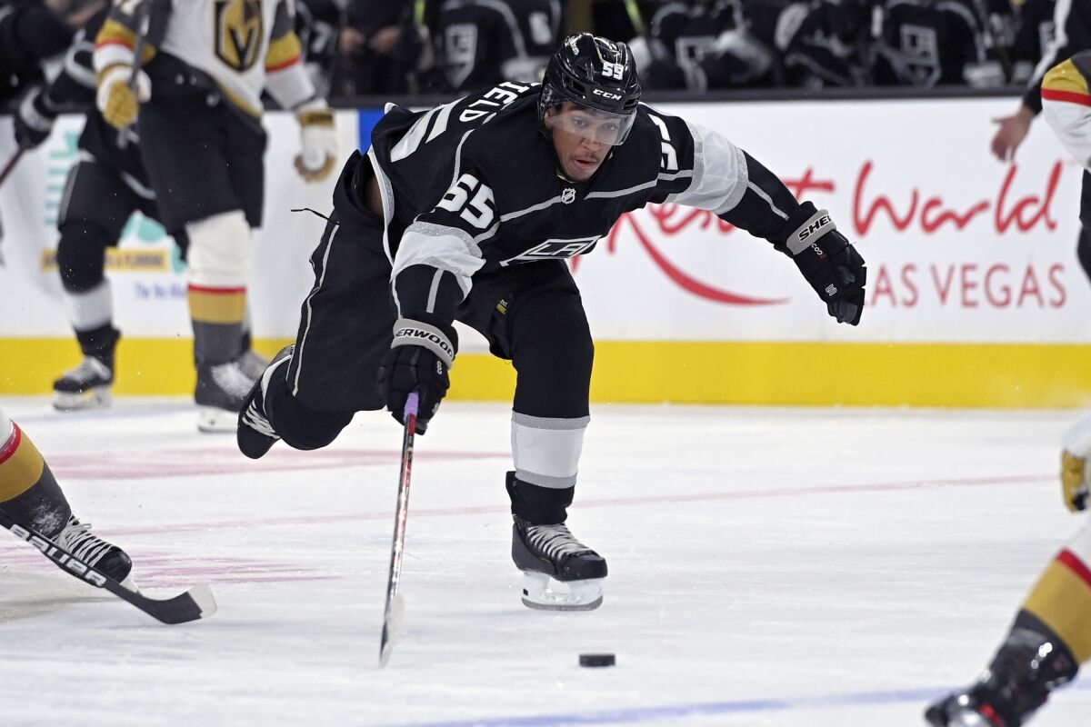 Los Angeles Kings center Quinton Byfield (55) reaches for the puck against the Vegas Golden Knights during the first period of an NHL preseason hockey game Friday, Oct. 1, 2021, in Las Vegas. (AP Photo/David Becker)