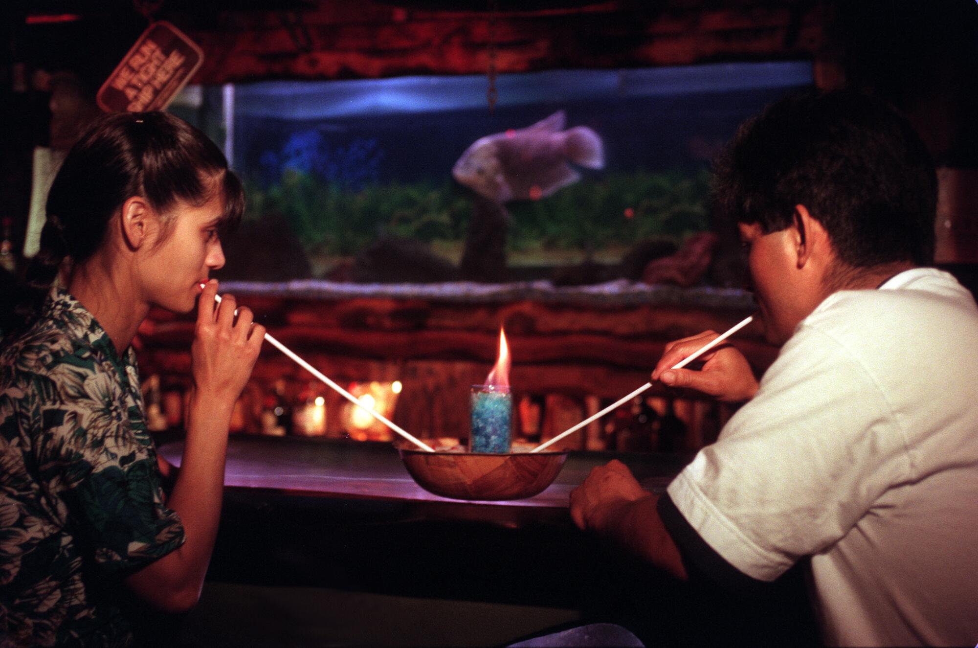 A young couple enjoy a flaming honey bowl  at the Bahooka Ribs & Grog restaurant in Rosemead.