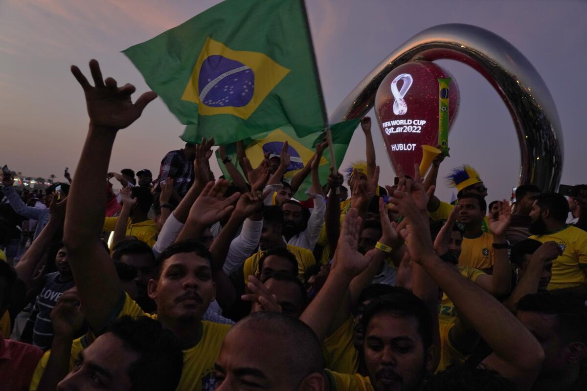 Fans cheer and wave Brazilian flags in front of t