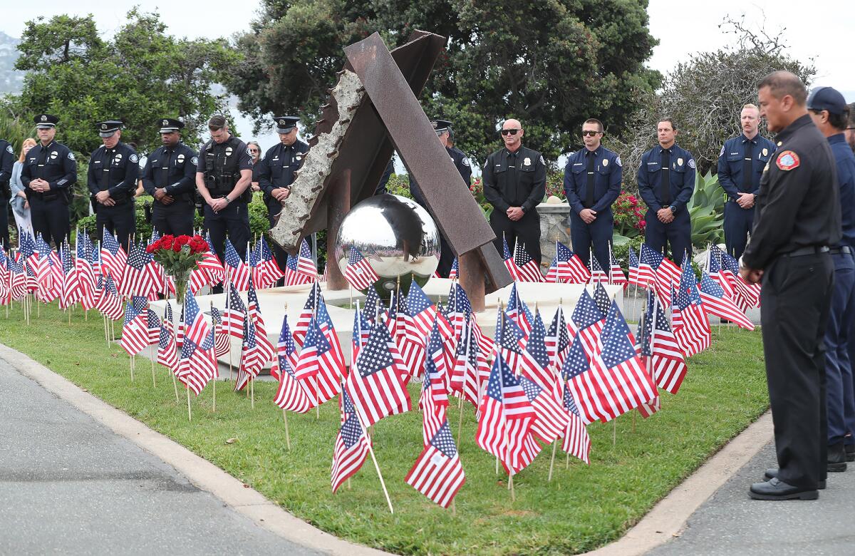 Laguna Beach fire and police personnel stand in a moment of silence at Monument Point in Heisler Park on Wednesday.