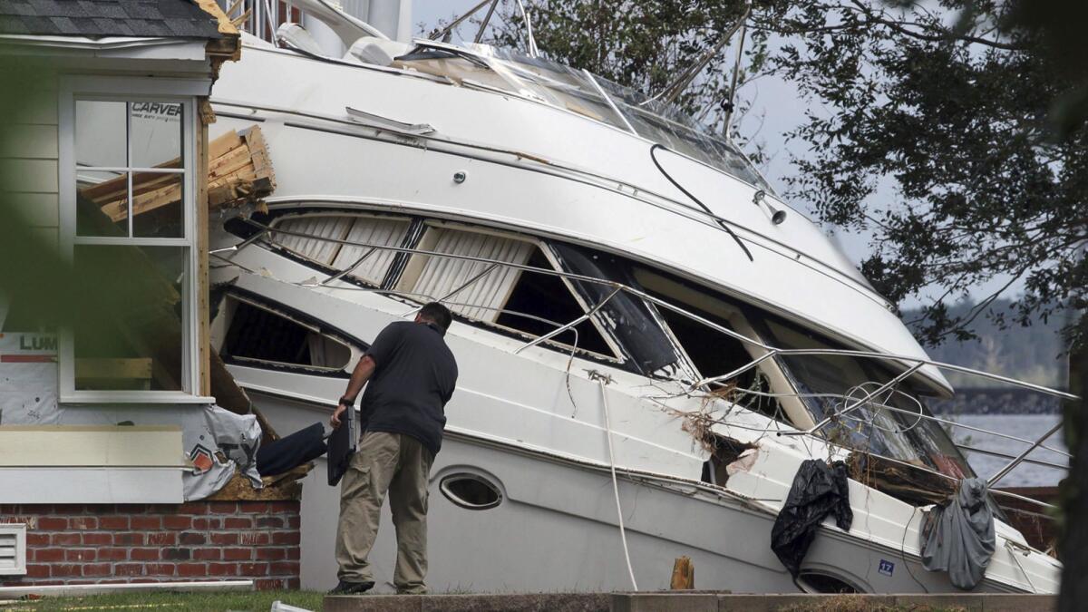 An insurance adjuster looks over a storm beached yacht off of East Front Street in New Bern, N.C., on Sept. 20.