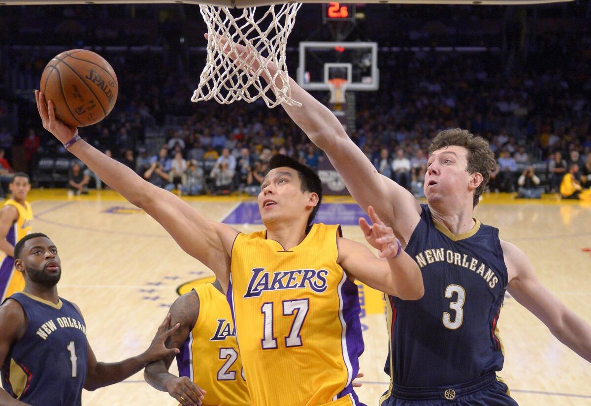 Lakers guard Jeremy Lin shoots next to New Orleans center Omer Asik on April 1.