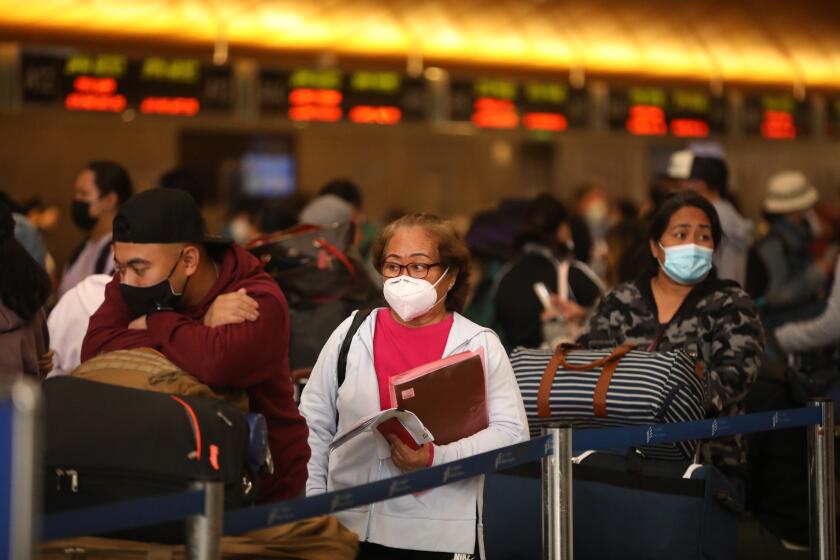 LOS ANGELES, CA - DECEMBER 3, 2021 - Travelers wait in a line to check-in at the Tom Bradley International Terminal at Los Angeles International Airport Friday, December 3, 2021. Los Angeles reported its first case of a person infected with the Omicron variant on Thursday, December 2. In partnership with the state and U.S. Centers for Disease Control and Prevention, the county set up a free rapid testing site for arriving passengers. (Genaro Molina / Los Angeles Times)