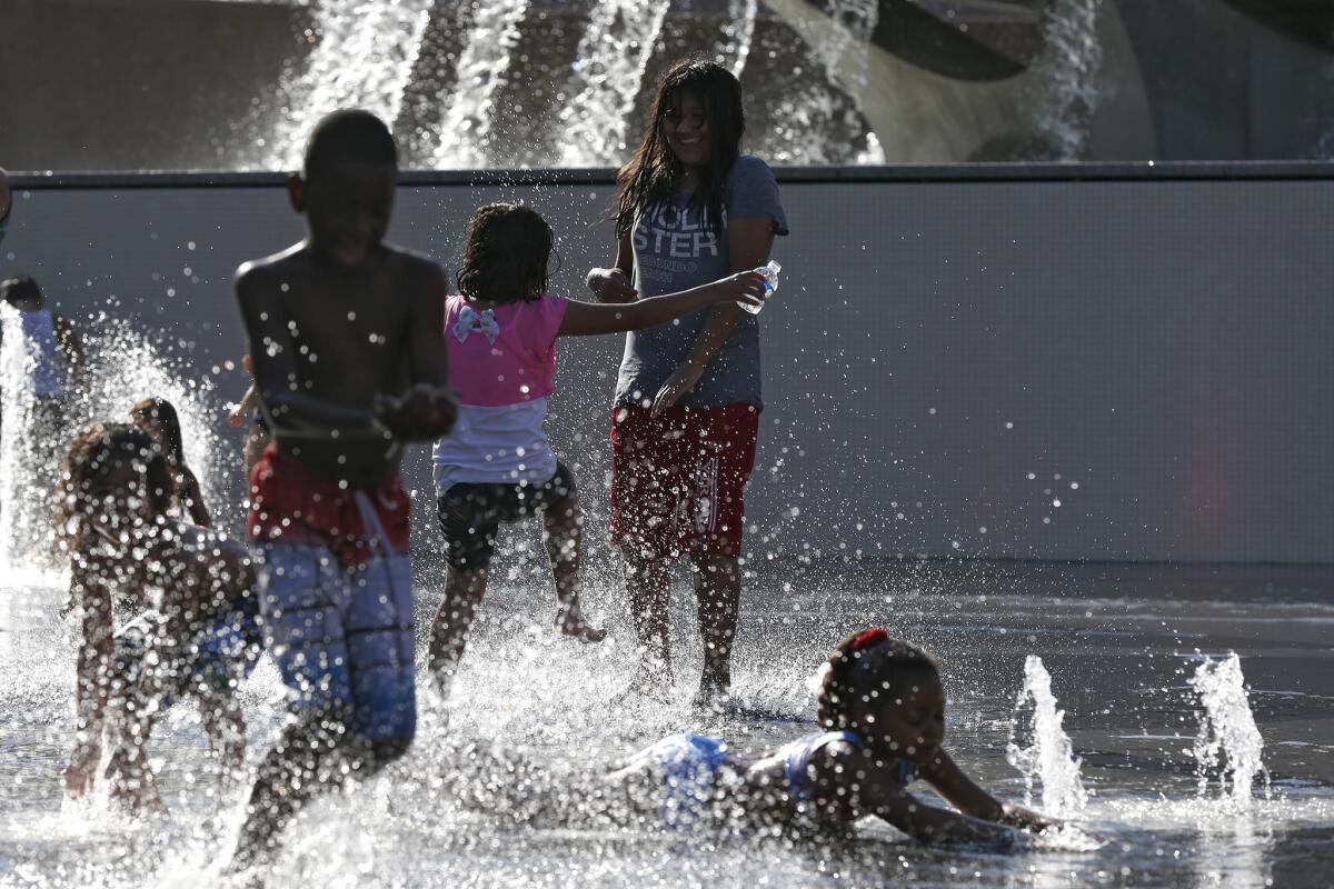 Children romp in a fountain at Grand Park on the Fourth of July.