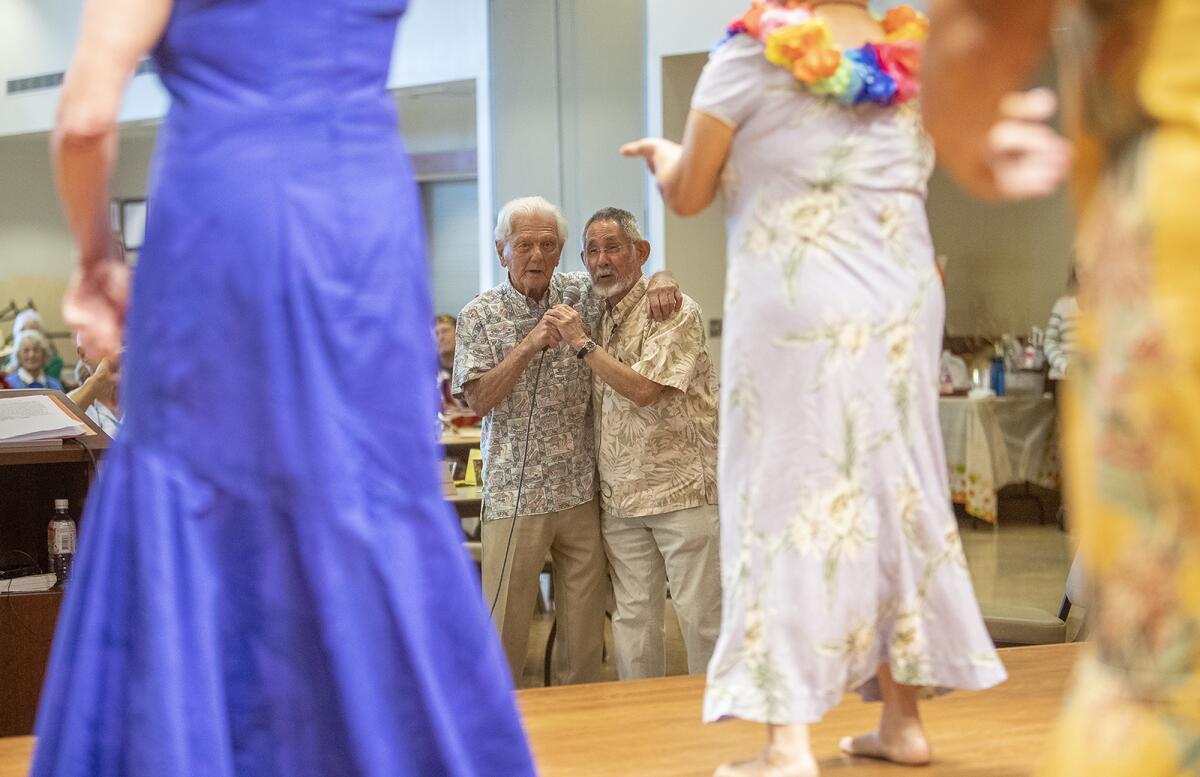 Tony Cappa, left, sings a song with Tim Ogawa during Cappa's retirement party Monday. Ogawa is succeeding Cappa as head of the Oasis ukulele club.