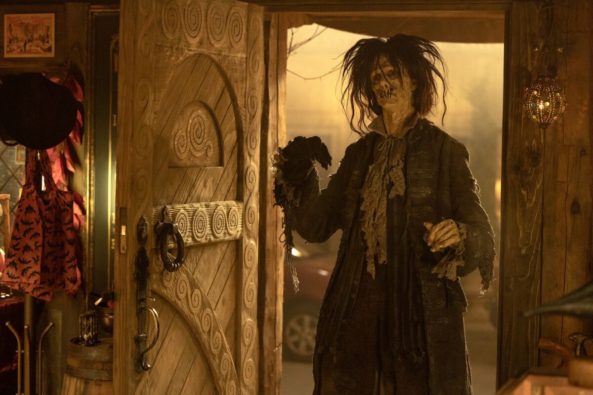 A man in period dress and long unkempt hair stands in a room in the movie "Hocus Pocus 2."