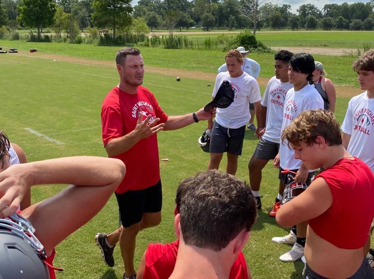 Retired NFL quarterback Philip Rivers talks to his players at St. Michael Catholic High in Fairhope, Ala.