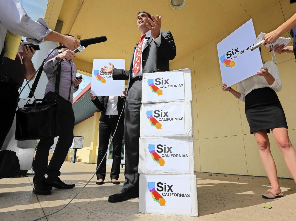 Silicon Valley venture capitalist Tim Draper talks Tuesday next to six boxes of petitions for a 2016 ballot initiative that would ask voters to split California into six separate states.