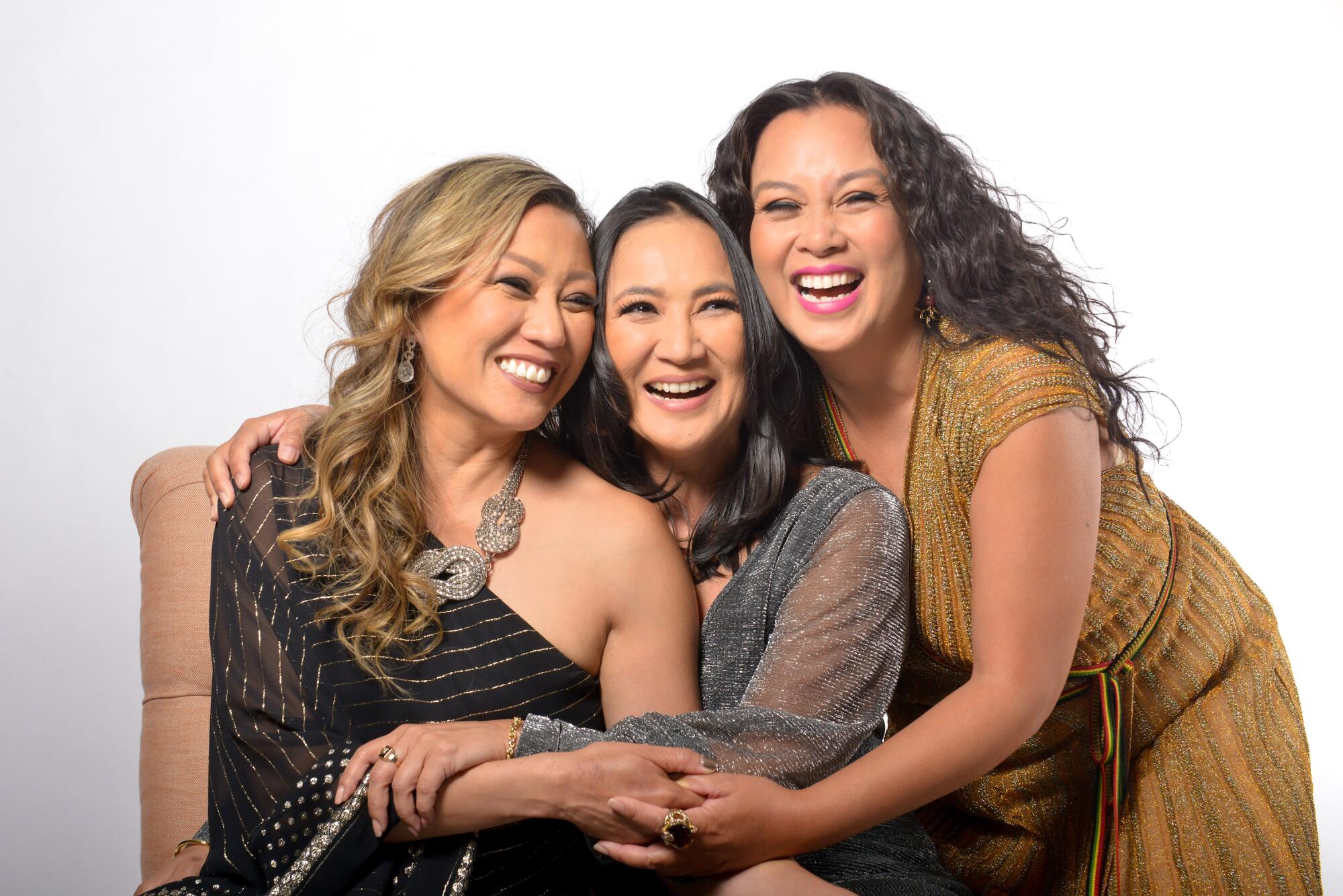 Three women hugging and smiling.