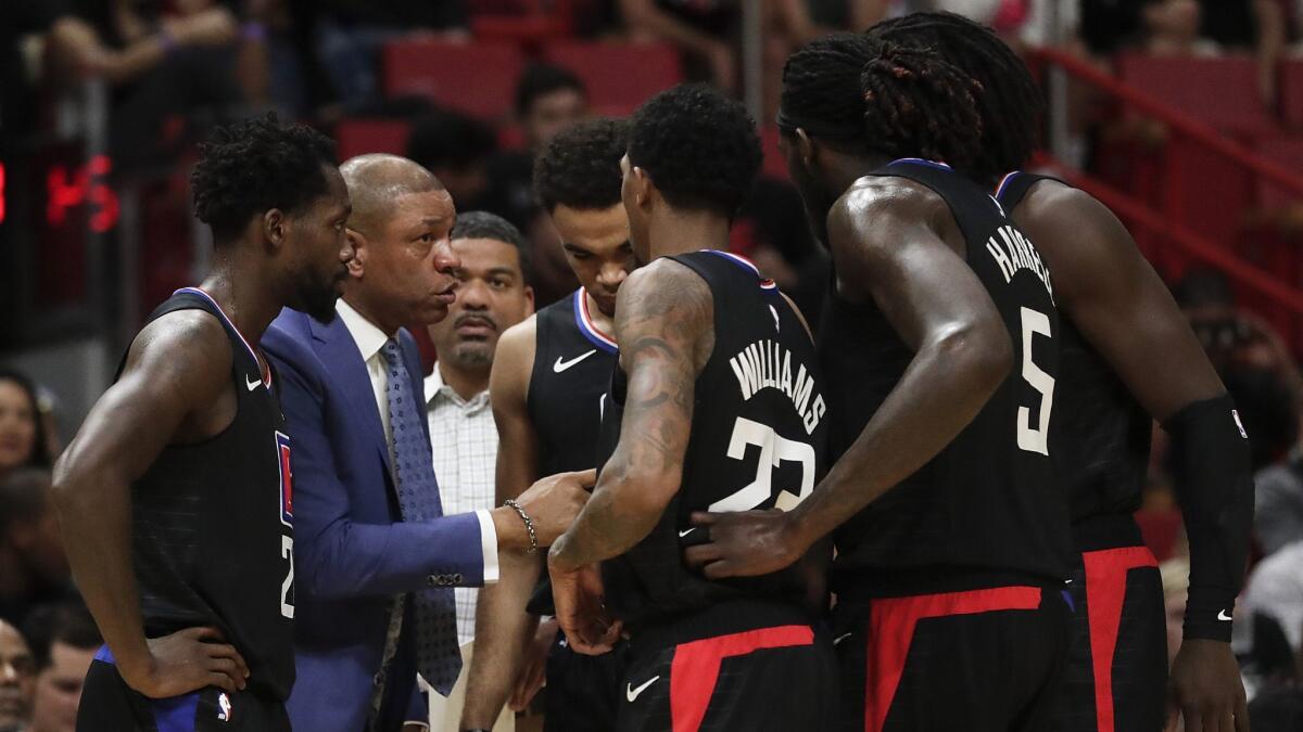 Clippers coach Doc Rivers huddles with players during a Jan. 23 game against Miami.