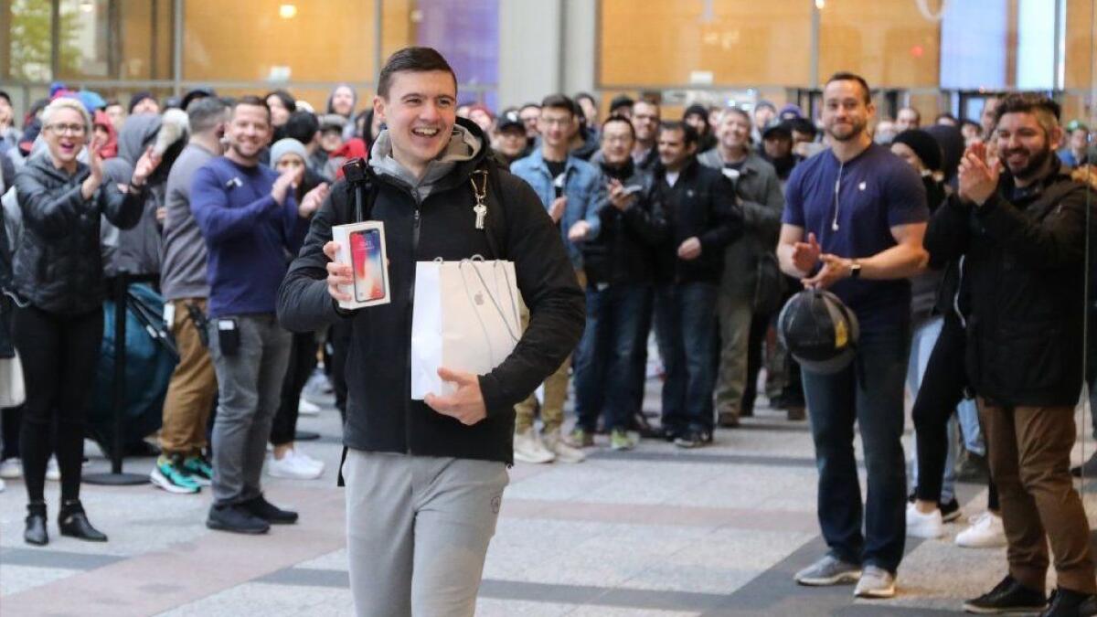 Customers outside an Apple store in Chicago cheer the iPhone X on its first day for sale in 2017. For some Apple devotees, the lack of 5G connectivity next year won’t be a deterrent.