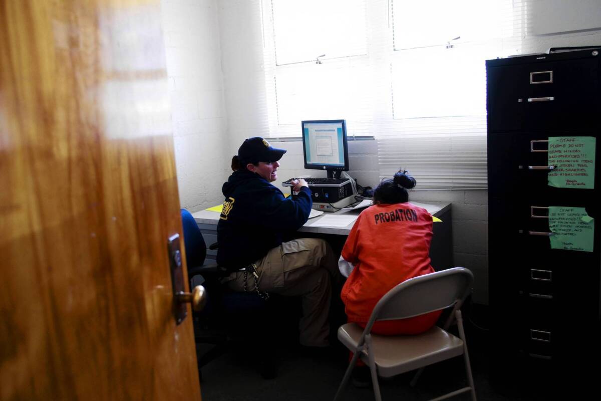 A probation officer helps a new arrival fill out paperwork at Camp Scudder, a locked facility in Santa Clarita run by the L.A. County Probation Department. The camp is testing a new screening program to address the health problems girls might face coming into the county's juvenile justice system and identify those who need help.