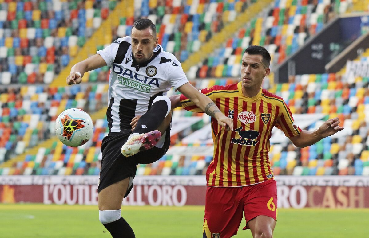 Lecce's Nehuén Paz, right, and and Udinese's Ilija Nestorovski vie for the ball during an Italian Serie A soccer match between Udinese and Lecce at the Dacia Arena stadium in Udine, Italy, Wednesday, July 29, 2020. (Andrea Bressanutti/LaPresse via AP)