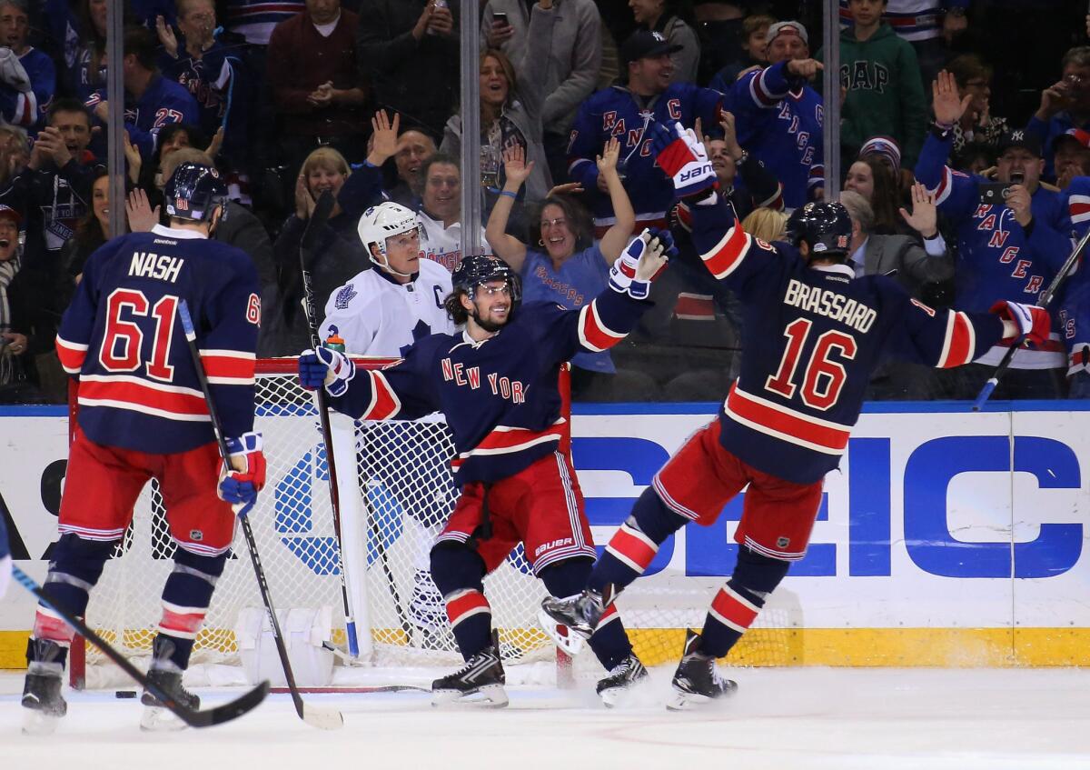 Rangers forward Mats Zuccarello, center celebrates scoring at hat trick against the Maple Leafs with teammates Rick Nash (61) and Derick Brassard (16).