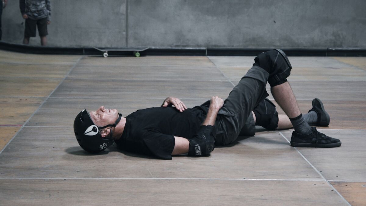 A middle-aged man wearing skateboarding gear lies on the ground in the documentary “Tony Hawk: Until the Wheels Fall Off.”