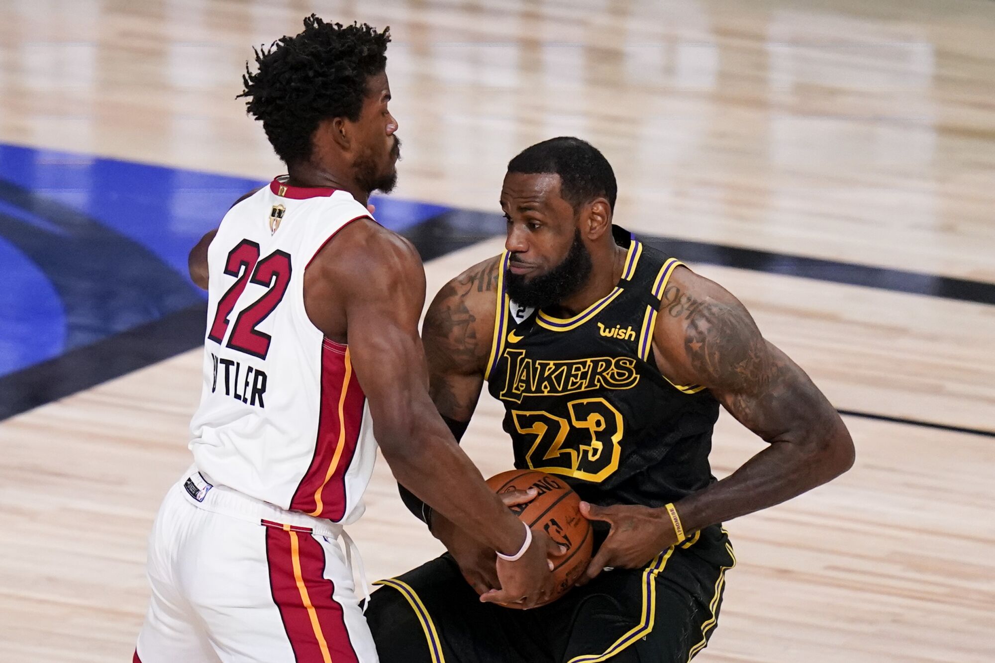 Heat forward Jimmy Butler tries to steal the ball from Lakers forward LeBron James during Game 5 on Friday night.