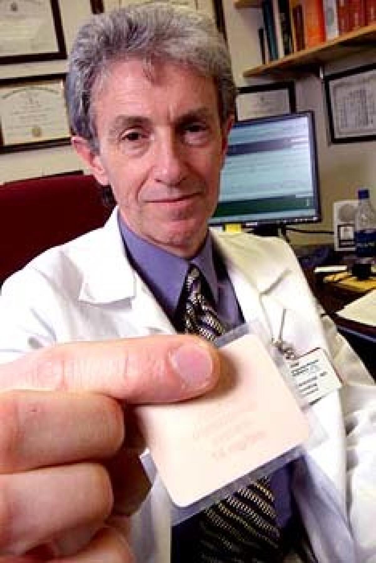 Dr. Paul Newhouse of the University of Vermont holds a nicotine patch, which he is researching as a possible treatment for cognitive impairment.
