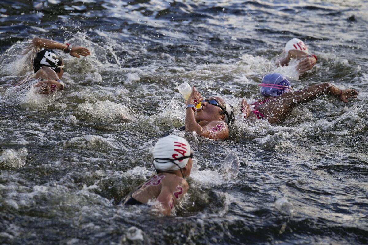 Samantha Arevalo of Ecuador takes a drink at a feeding station during the women's marathon swimming event Wednesday.