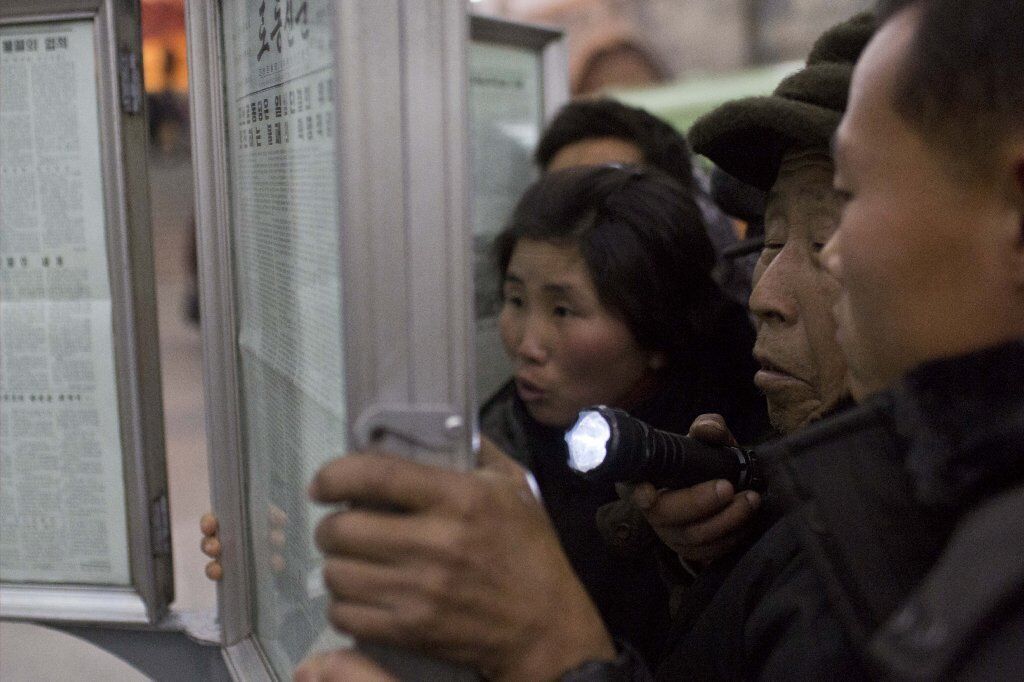 North Koreans crowd a public newspaper stand for news of the execution.