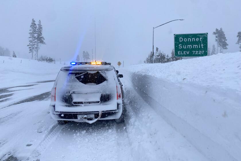 A California Highway Patrol vehicle drives through snow at Donner Summit on Sunday, Dec. 25. Interstate 80 was closed over the Sierra Nevada due to whiteout conditions.