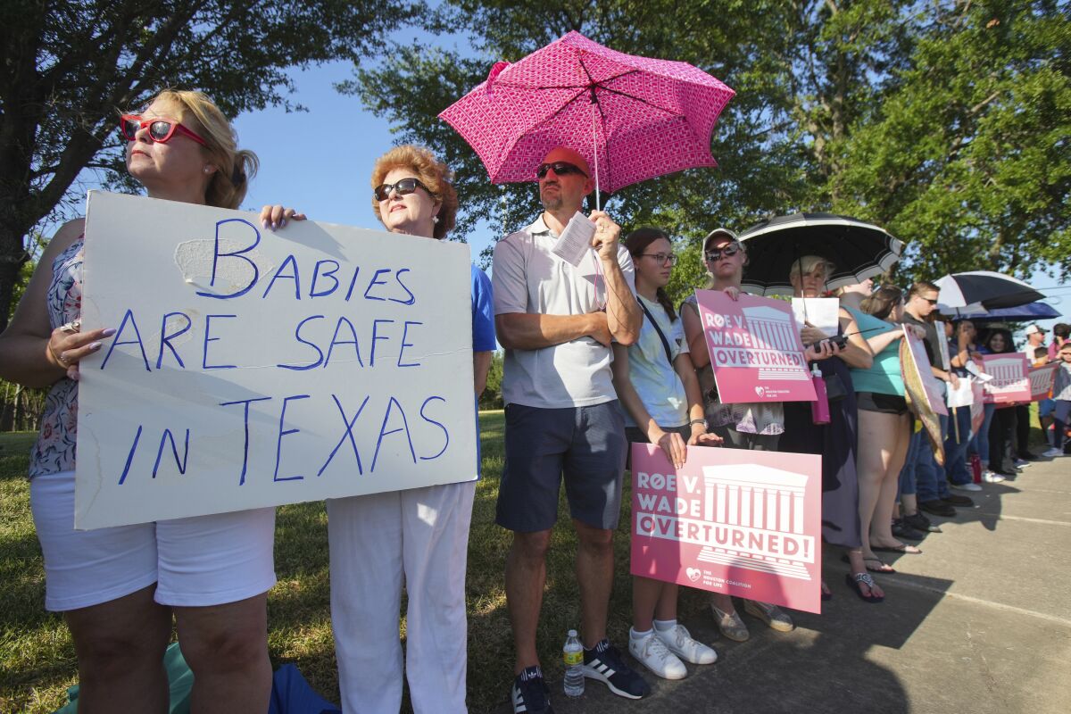 FILE - Linda Banes, left, and Ethelene Marshall stand with anti-abortion demonstrators as they gathered to sing and pray outside Planned Parenthood in Houston, June, 24, 2022, after the U.S. Supreme Court overturned Roe v Wade. Three women in Texas are being sued for wrongful death by a man who claims they helped his now-ex-wife obtain medication for an abortion. In a lawsuit filed late Thursday, March 9, 2023, in Galveston County, Texas, Marcus Silva alleges assisting in a self-administered abortion is tantamount to aiding a murder. (Brett Coomer/Houston Chronicle via AP, File)