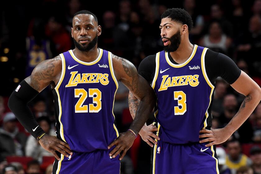 LeBron James #23 and Anthony Davis #3 of the Los Angeles Lakers speak during a time out.