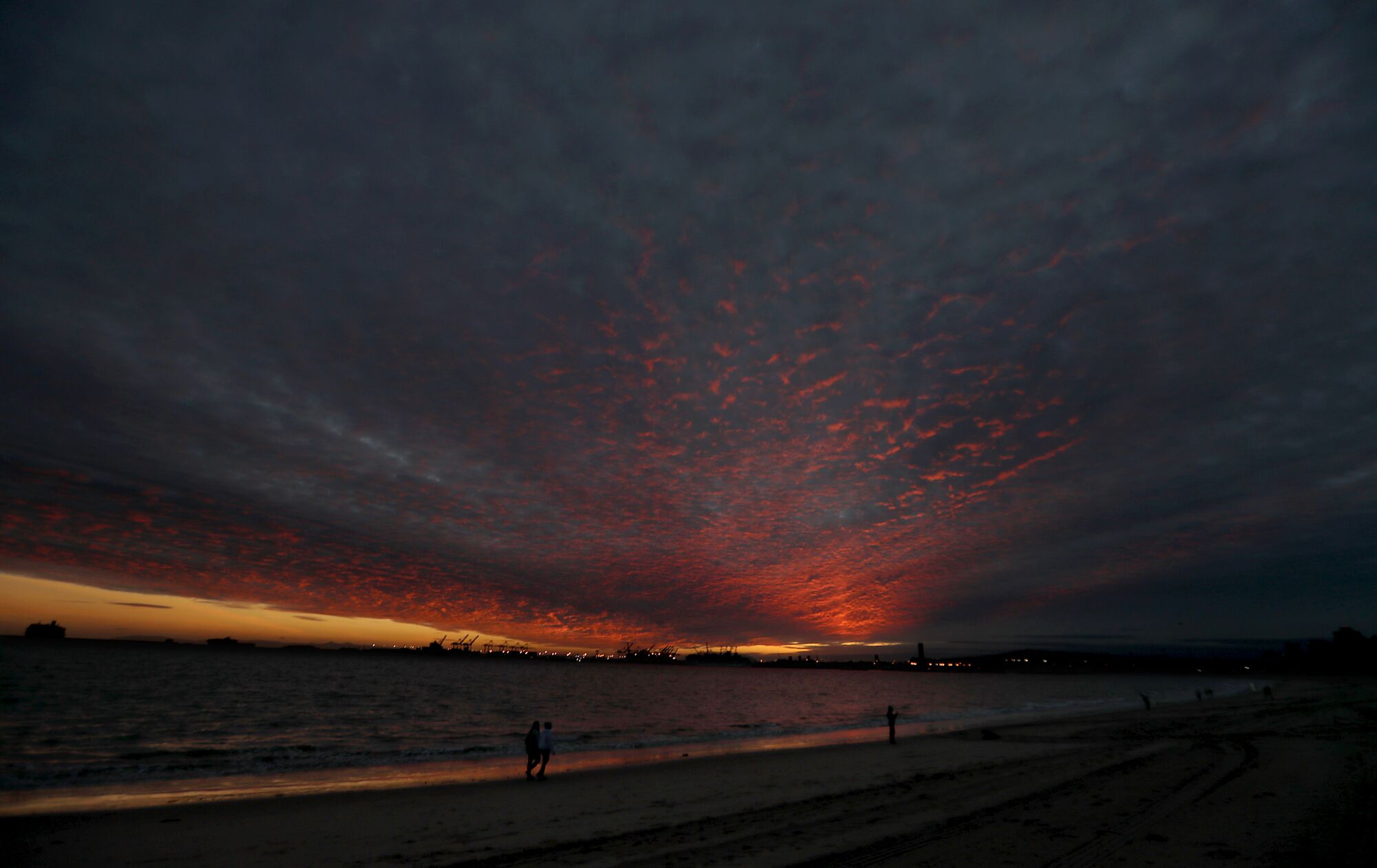The setting sun paints the clouds coming ashore in Long Beach ahead of a powerful storm 