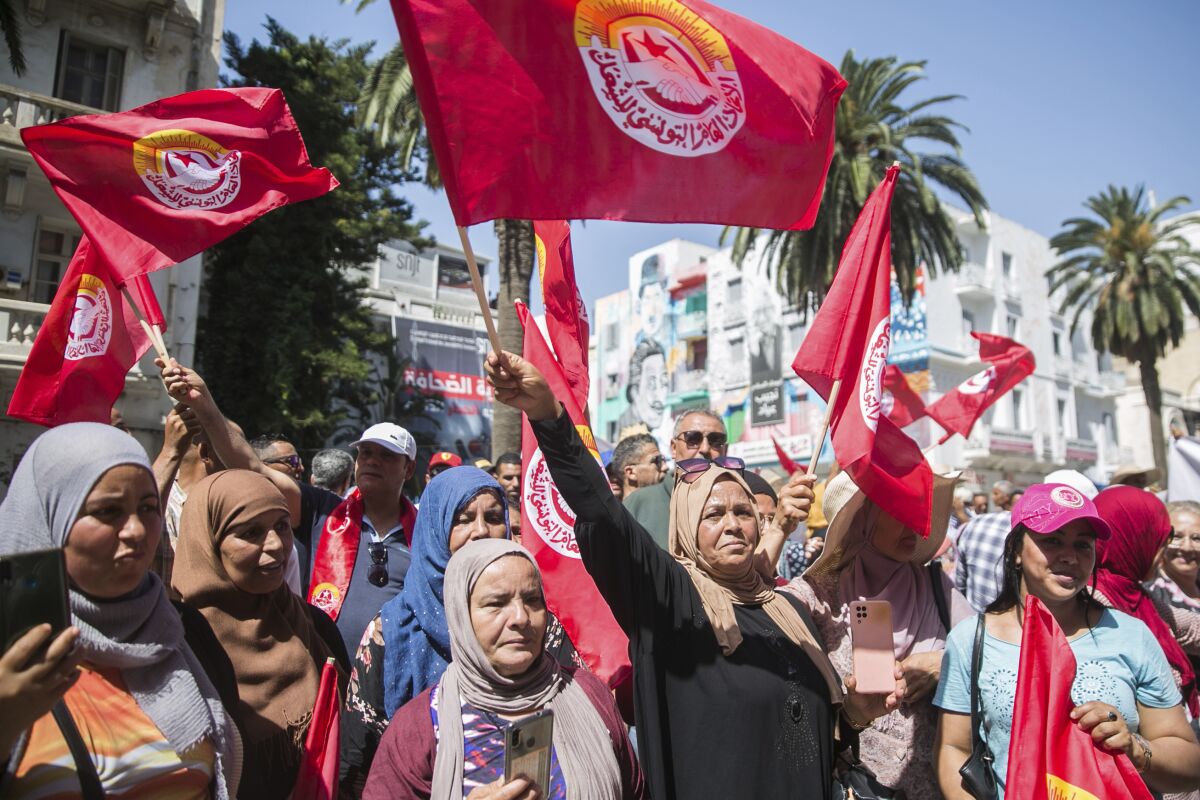 Supporters of the Tunisian General Labor Union (UGTT) gather during a rally outside its headquarters in Tunis, Tunisia, Thursday, June 16, 2022. A nationwide public sector strike in Tunisia is poised to paralyze land and air transportation and other vital activities Thursday with the North African nation already in the midst of a deteriorating economic crisis. (AP Photo/Hassene Dridi)