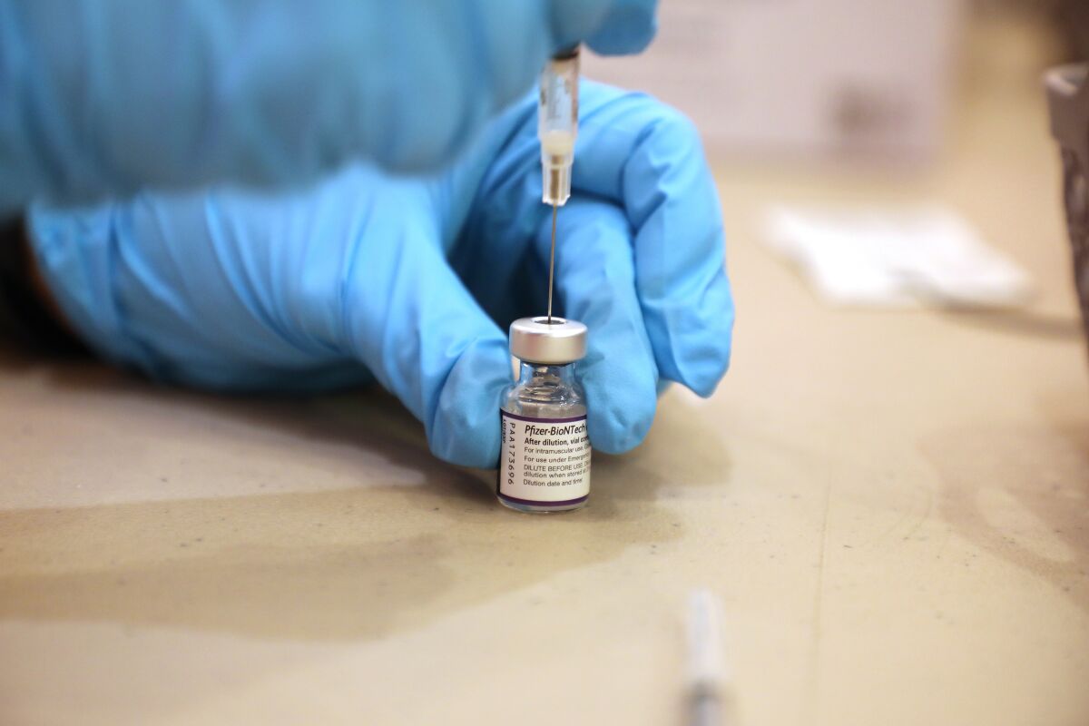 A pharmacist prepares a dose of the Pfizer-BioNTech COVID-19 vaccine.