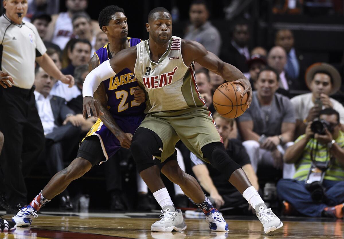 Miami Heat guard Dwyane Wade is defended by Lakers guard Lou Williams during the second quarter of at game on Nov. 10.