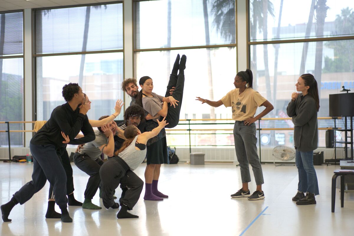 Dansers werken in een trainingsstudio met een choreograaf.