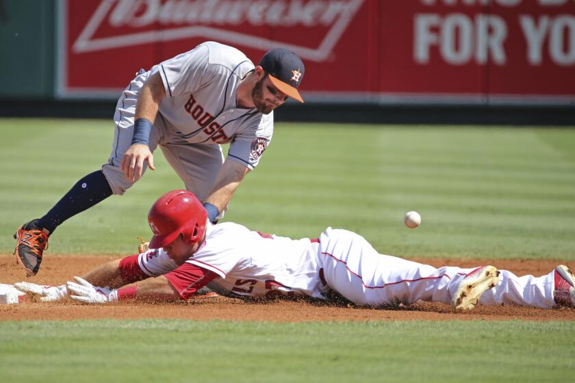 Astros second baseman Tyler White loses the ball as Angels outfielder Mike Trout steals his 30th base on the season.