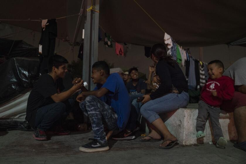 Central American asylum-seeking teenagers play in an encampment where they live near the Gateway International Bridge on Friday, Nov. 22, 2019 in Matamoros, Mexico. Verónica G. Cárdenas / For The Times