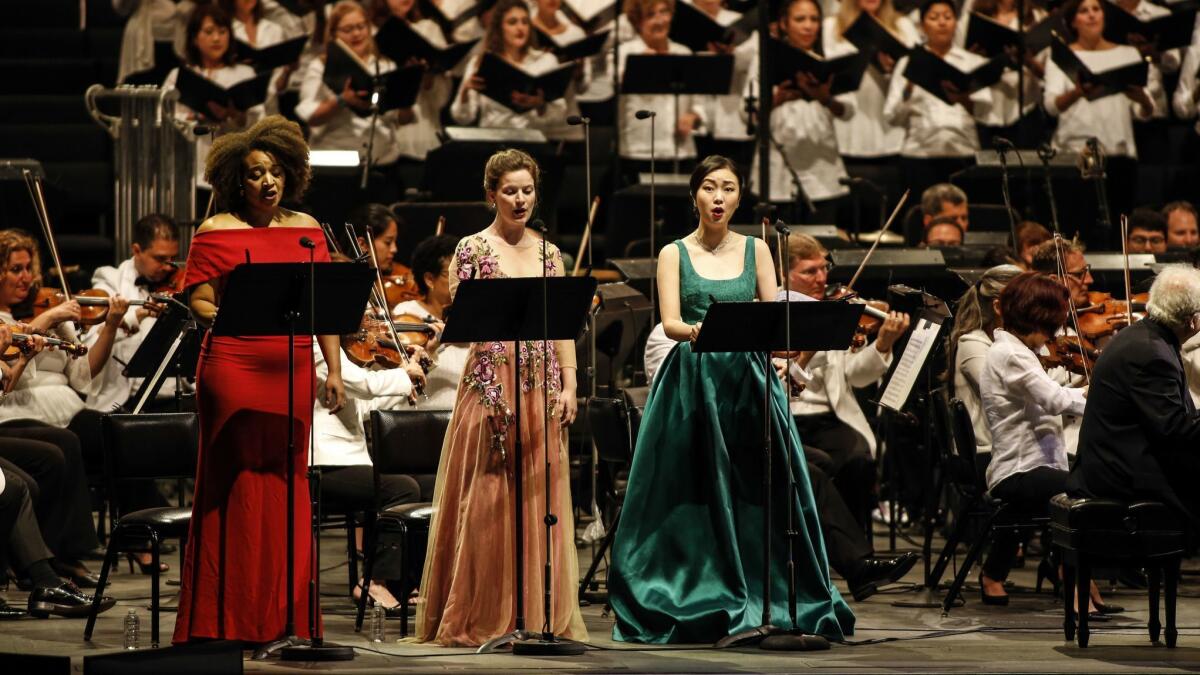 Taylor Raven, left, Liv Redpath and Ying Fang on the Hollywood Bowl stage, with the Los Angeles Philharmonic and the L.A. Master Chorale in back.