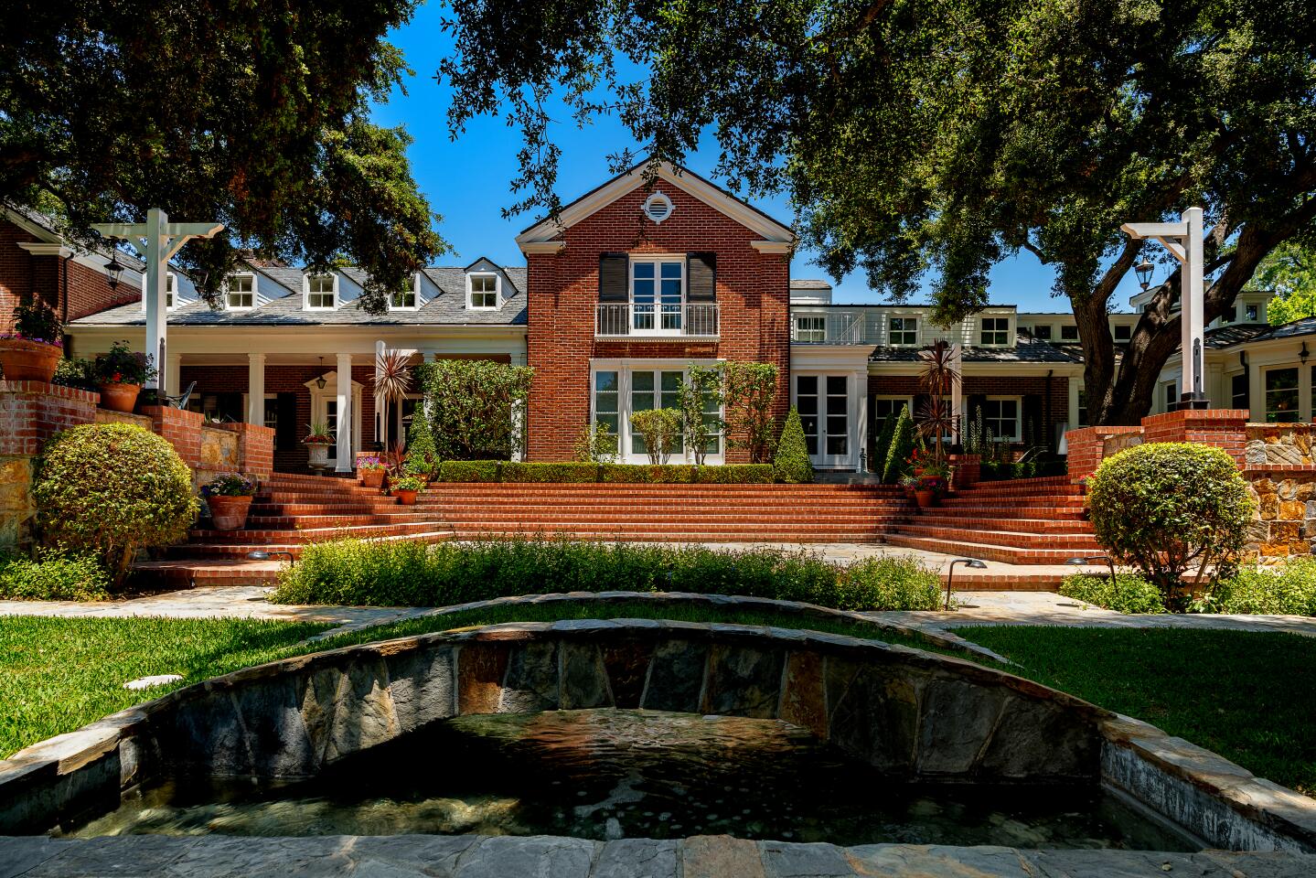 Fountains, a lawn and mature oak trees fill the grounds.