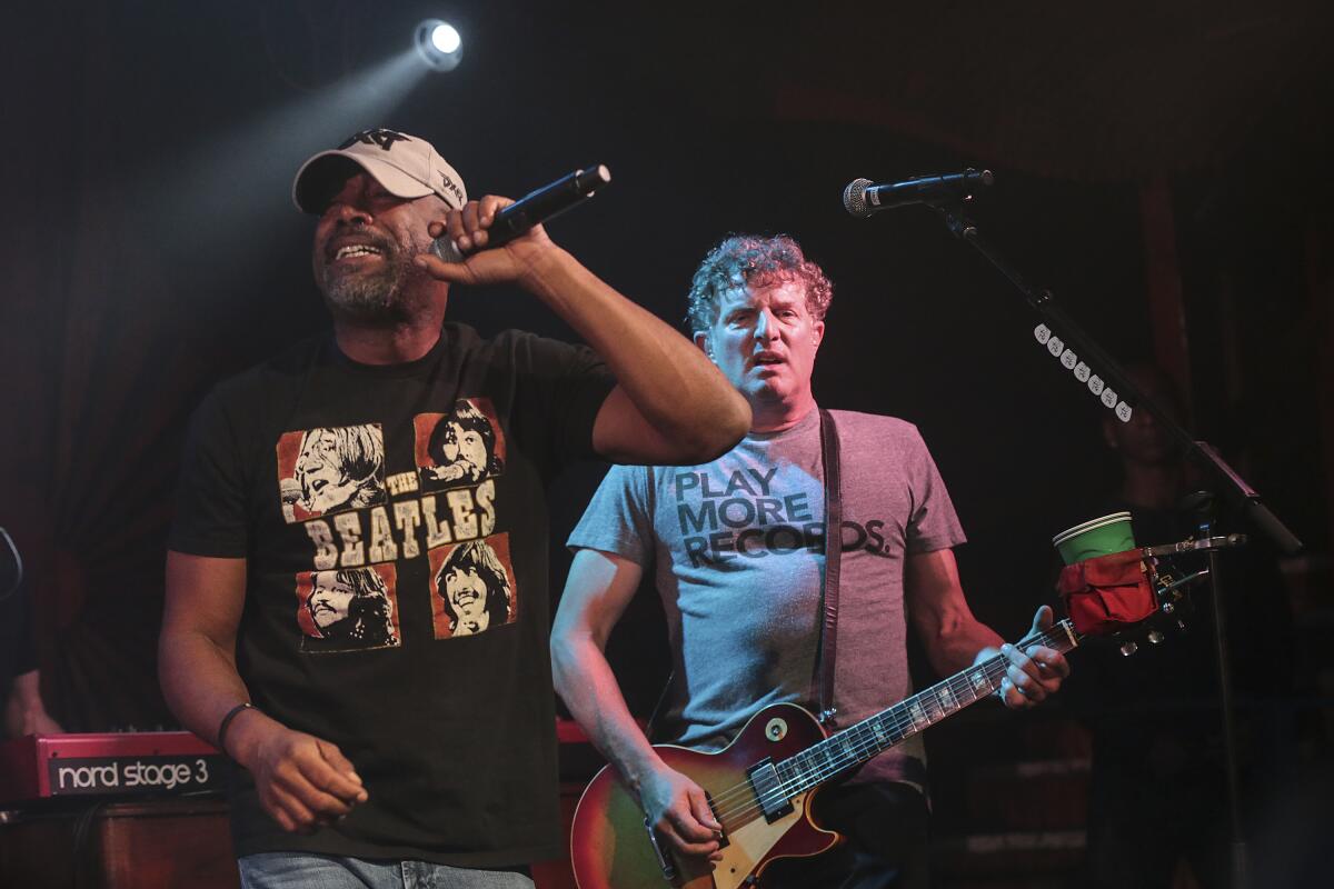 Hootie & the Blowfish singer Darius Rucker, in a black Beatles' "Let It Be" album cover T-shirt, and guitarist Mark Bryan, in a gray T-shirt that says "Play More Records."