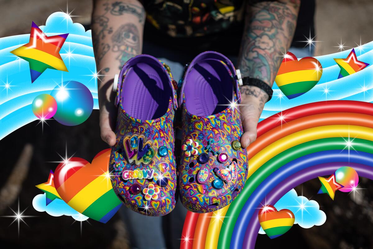 A person holds brightly decorated Crocs.