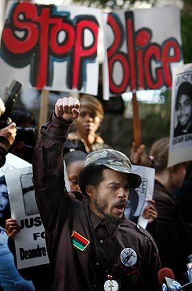 Shango Abiola shouts and raises his fist during a press conference in front of the Criminal Courts building in Los Angeles over the hearing going on inside for former Bay Area Rapid Transit officer Johannes Mehserle, who is charged with the shooting death of 22-year-old Oscar Grant last year.