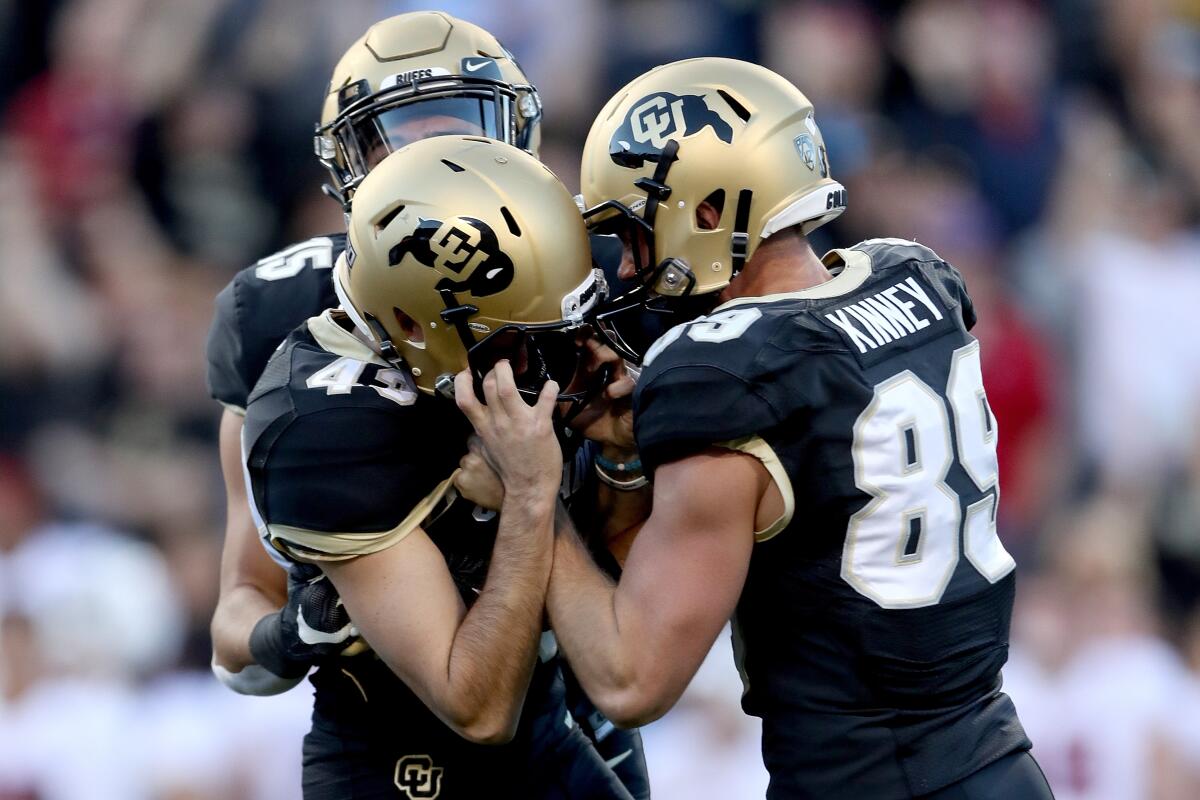 Colorado's Legend Brumbaugh (15), Alex Kinney (89) and Evan Price (43) celebrate  a game winning  field goal by Price against Stanford Cardinal in the final seconds on Saturday.