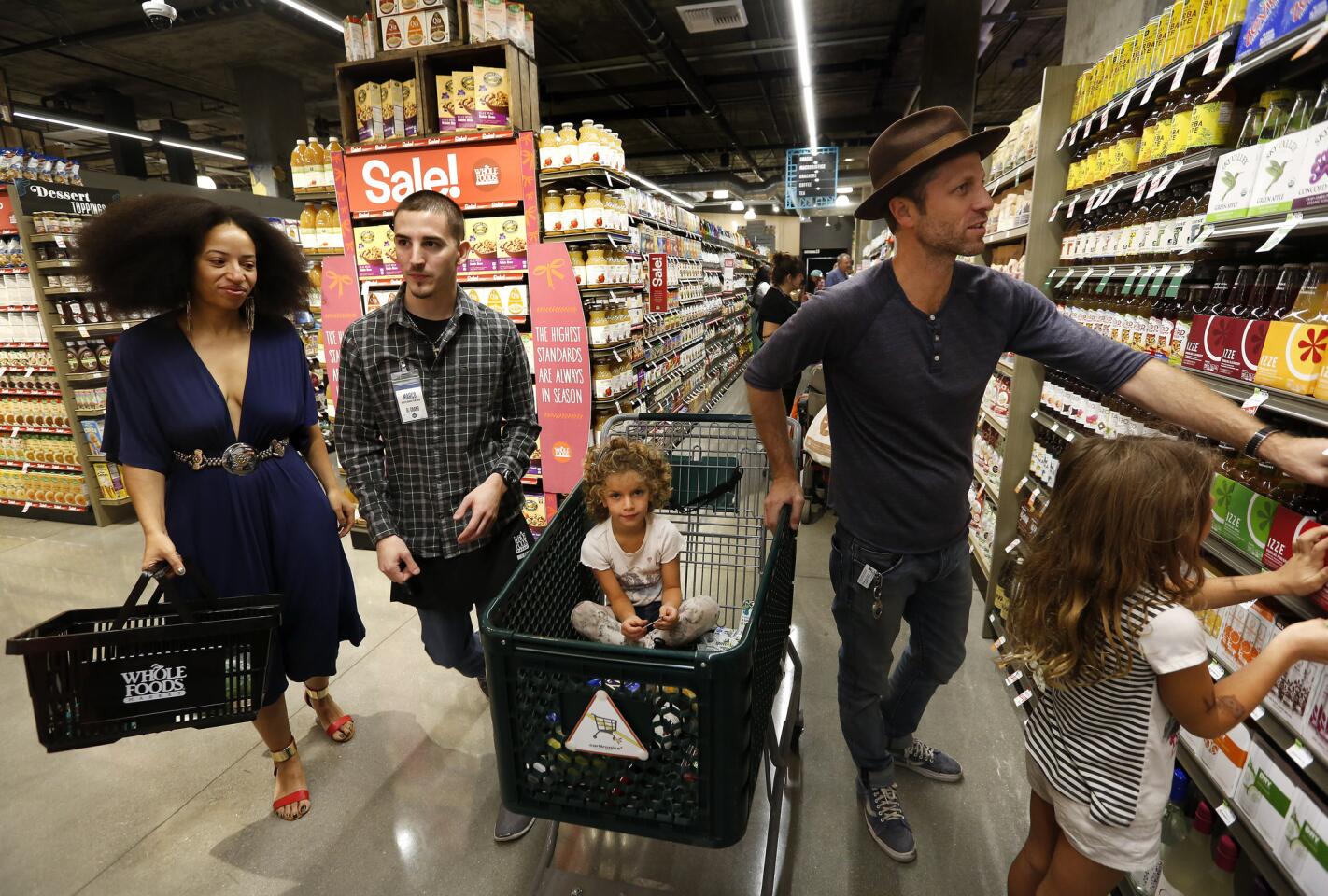 Michael Leone, right, shops with his daughters, Simone, 4, left, and Lucia, 6, at a new Whole Foods Market that opened Wednesday in downtown Los Angeles.