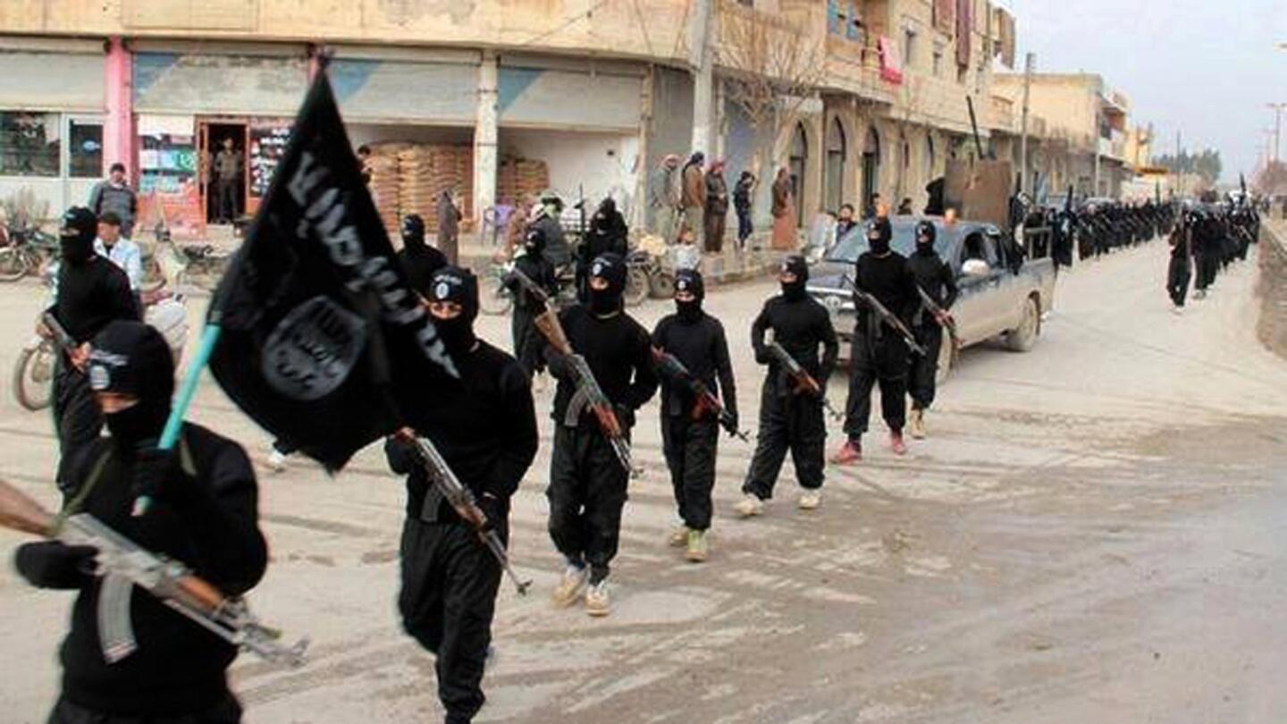 Esta imagen colocada en un cibersitio de miilicianos el 14 de enero del 2014 muestra a combatientes del Estado Islámico marchando por Raqqqa, Siria.