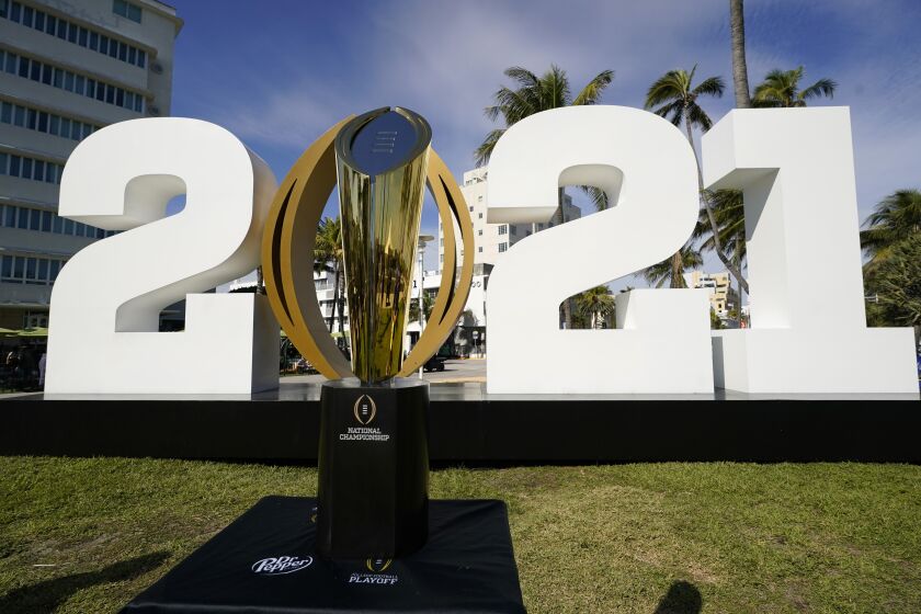 FILE - In this Jan. 7, 2021, file photo, the trophy for the College Football Playoff championship NCAA college football game is displayed along Ocean Drive, in Miami Beach, Fla. The College Football Playoff management committee is scheduled to meet Wednesday, Sept. 22, 2021, to discuss the feedback members have received from campuses since a 12-team expansion plan was unveiled in June. (AP Photo/Lynne Sladky, File)