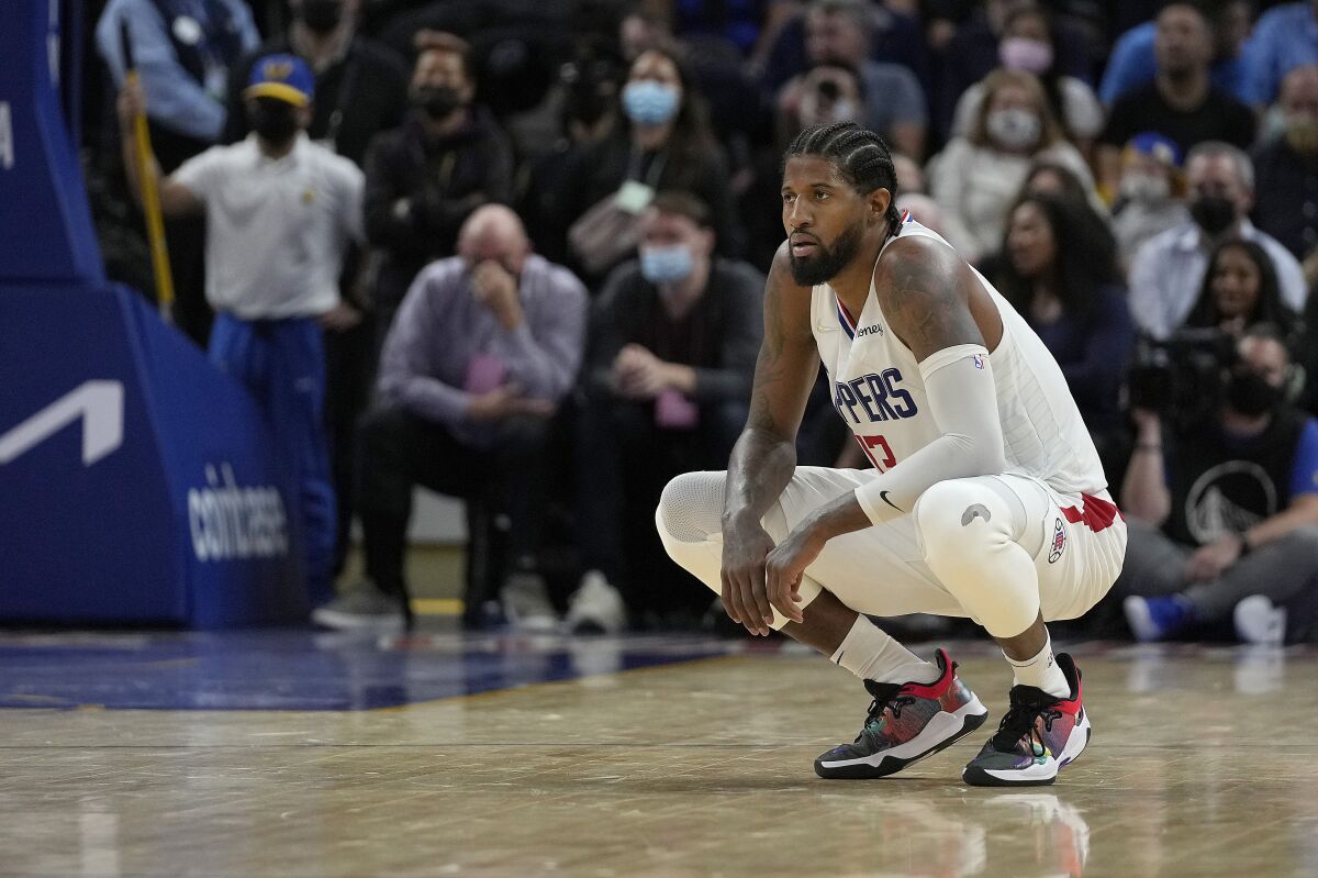 Clippers guard Paul George squats on the court during the second half Thursday against the Golden State Warriors