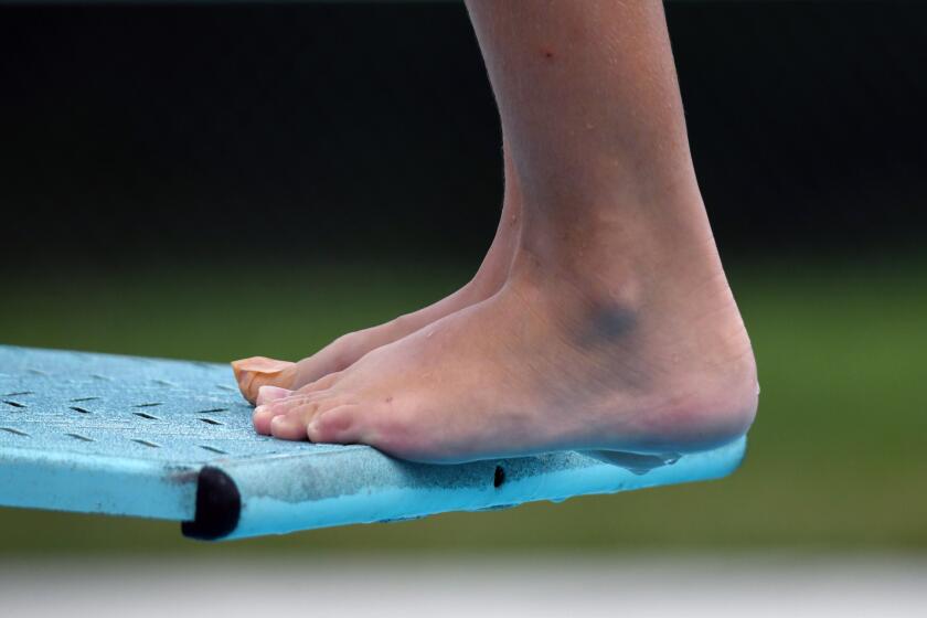 A diver edges his feet over the spring board during competition between West Howard and. North Saint Johns.