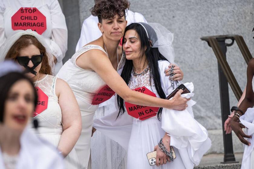 Chavie Weisberger hugs fellow child marriage survivor Fatemah on the west steps of the California state Capitol.