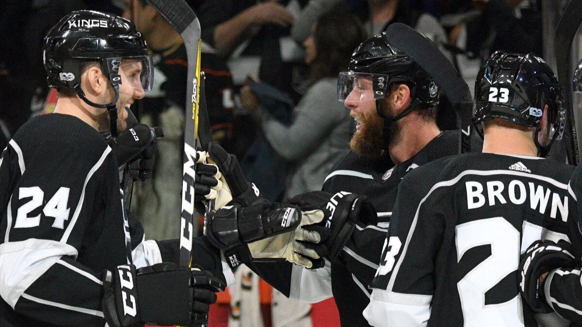 Kings defenseman Jake Muzzin, center, is congratulated after scoring the winning goal in overtime to beat the Ducks during a preseason game on Saturday.