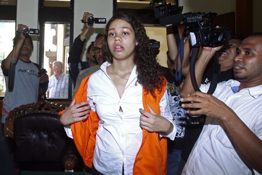 FILE - Heather Mack of Chicago, Ill., center, is mobbed by reporters as she arrives in the courtroom for her sentencing hearing at a district court in Denpasar, Bali, Indonesia, April 21, 2015. The Chicago woman facing federal conspiracy charges in the 2014 killing of her mother during a luxury vacation in Bali plans to plead guilty, her attorney said Thursday, June 1, 2023. (AP Photo/Firdia Lisnawati, File)